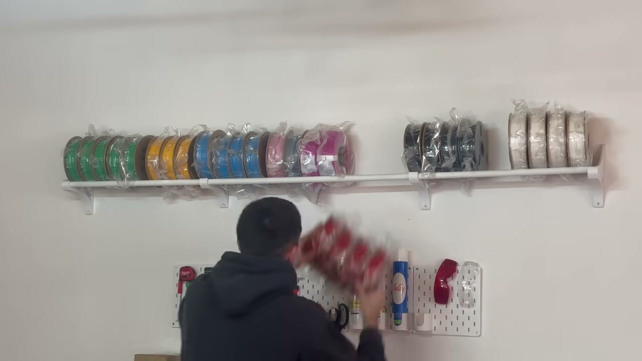 Bobinas de filamento de varios colores organizadas en una pared