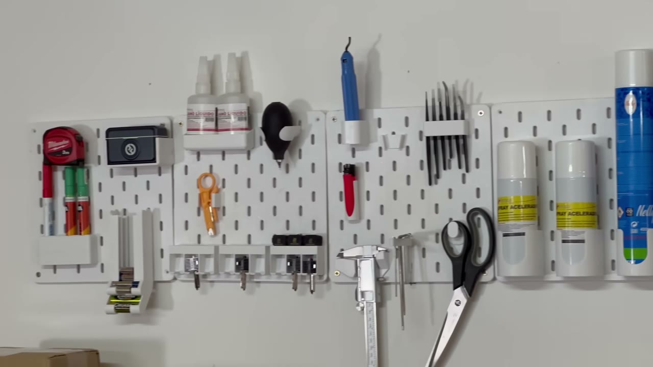 Panel perforado con herramientas organizadas en soportes impresos en 3D