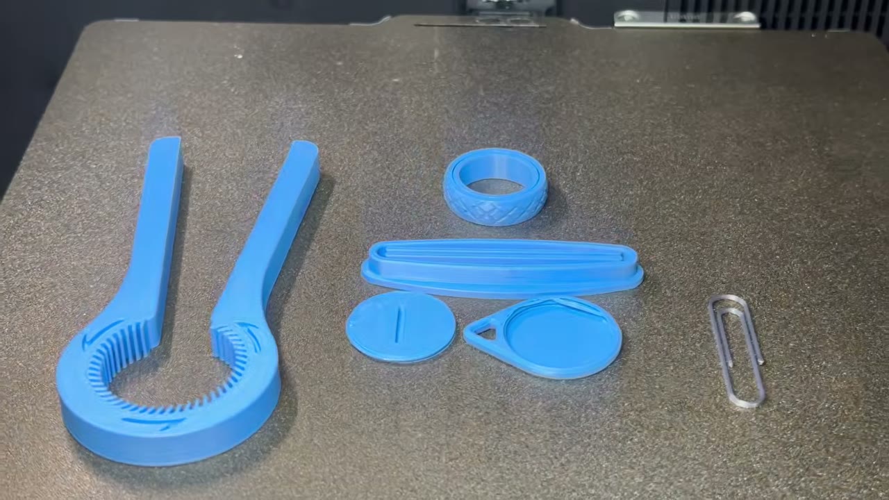 Varios objetos útiles impresos en 3D en PLA azul sobre la placa de impresión